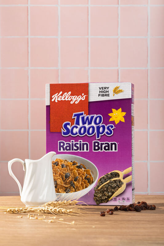 Kellogg's Two Scoops Raisin Bran box styled with a cereal bowl on pink tile