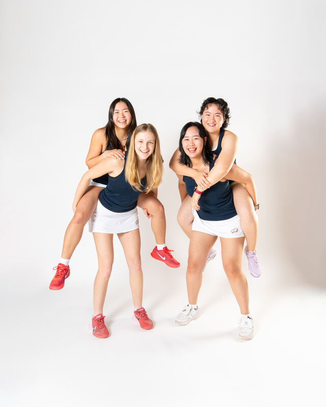 UBC Thunderbirds women's tennis players piggybacking and laughing on white