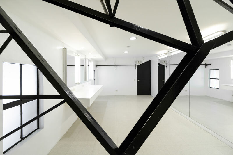 Black steel frame lines crossing a bright white event space at Whitespace Manila